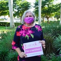 image of a woman wearing a blue dress with flowers on it, holding a sign